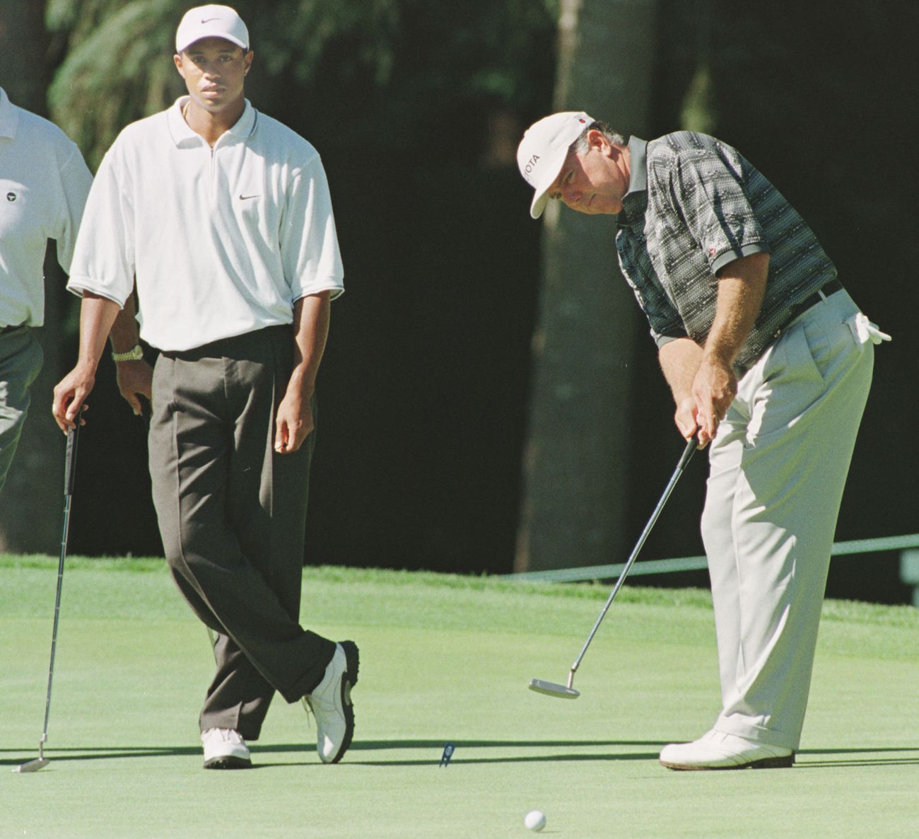 Tiger Woods watches Mark O'Meara putt ahead of the 1998 PGA Championship. 
