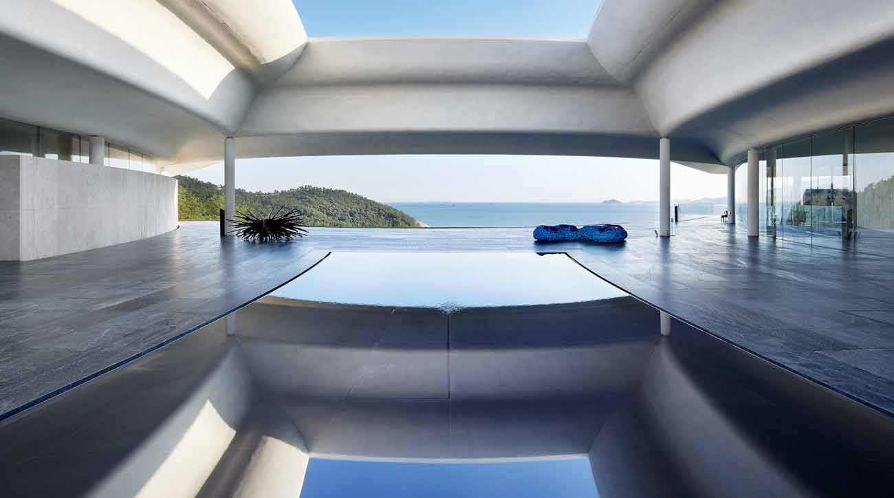 The resort’s entrance features an open roof, reflecting pool and gorgeously framed view of the South Sea.