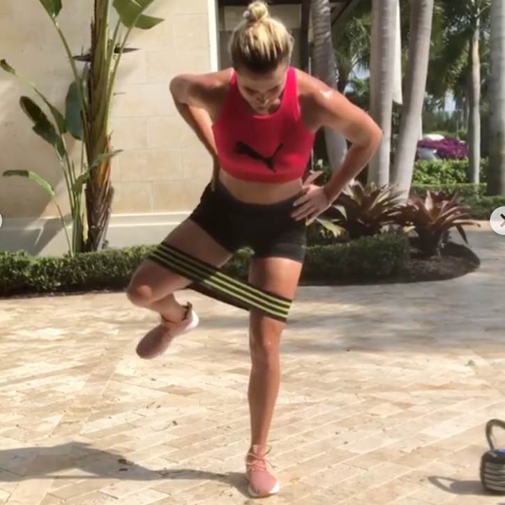 The third exercise in Lexi's workout is a banded hip rotation. 