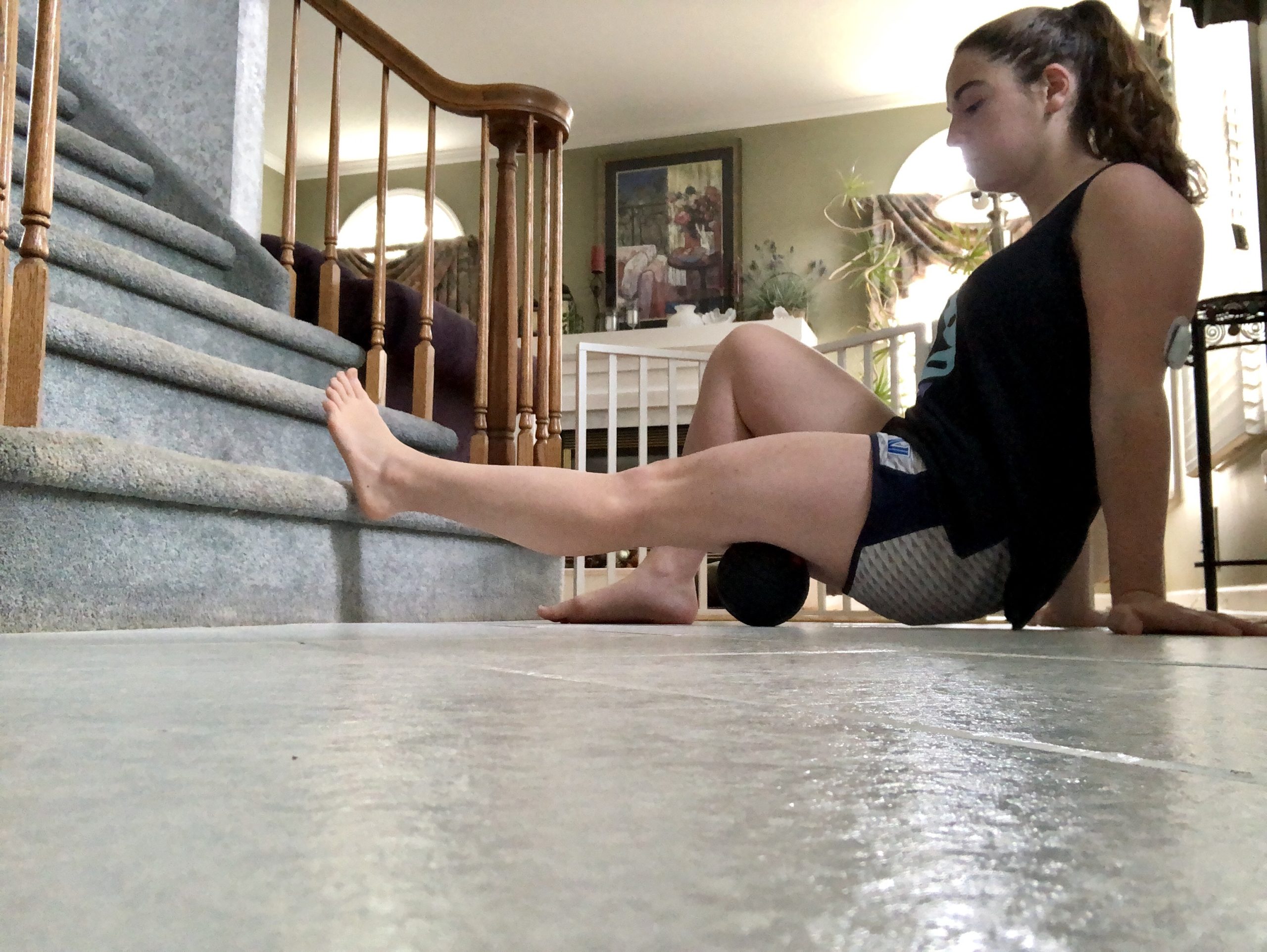 A girl uses a foam roller to loosen her muscles.