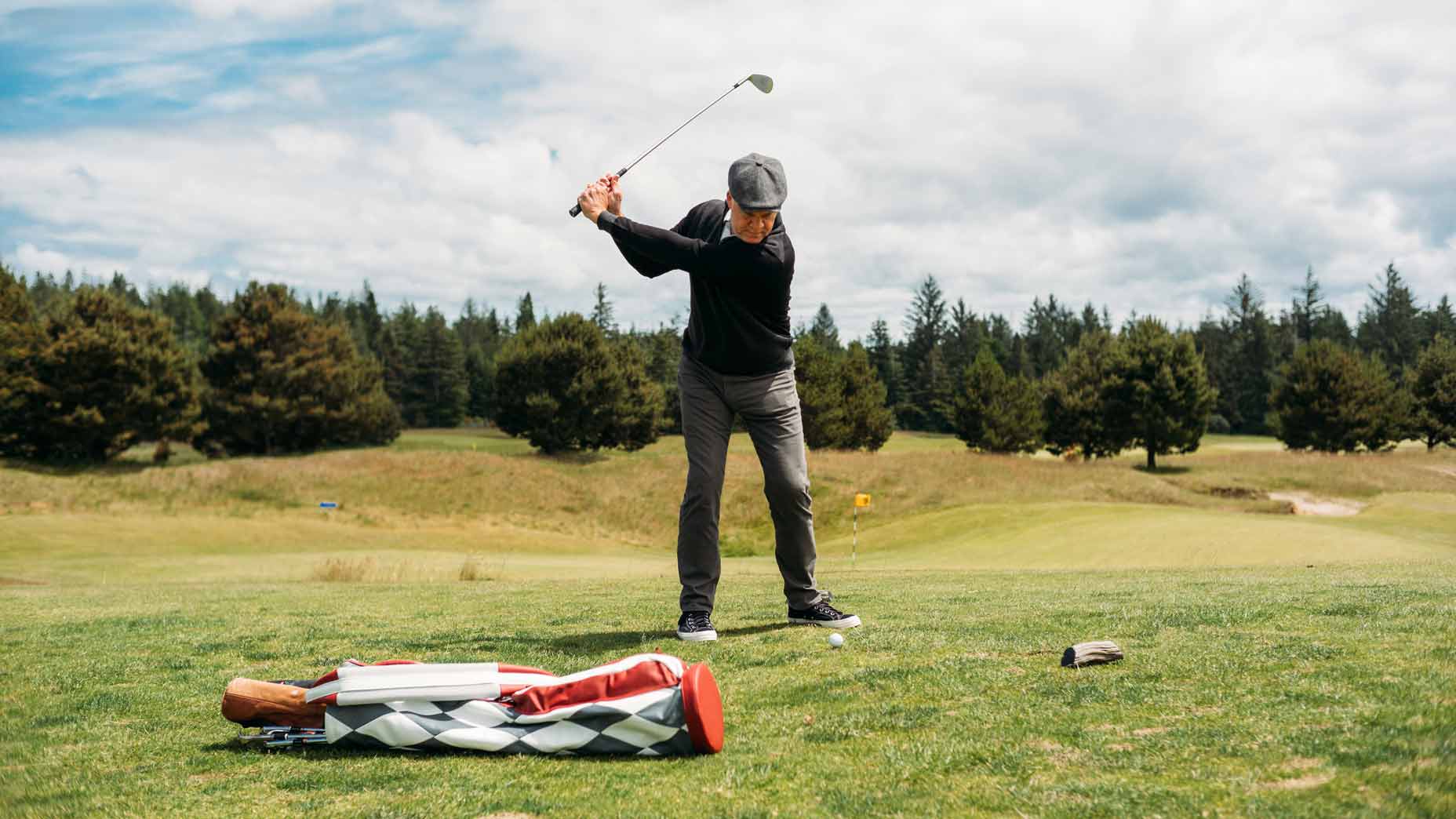 Todd Rohrer swinging next to Macdonald golf bag
