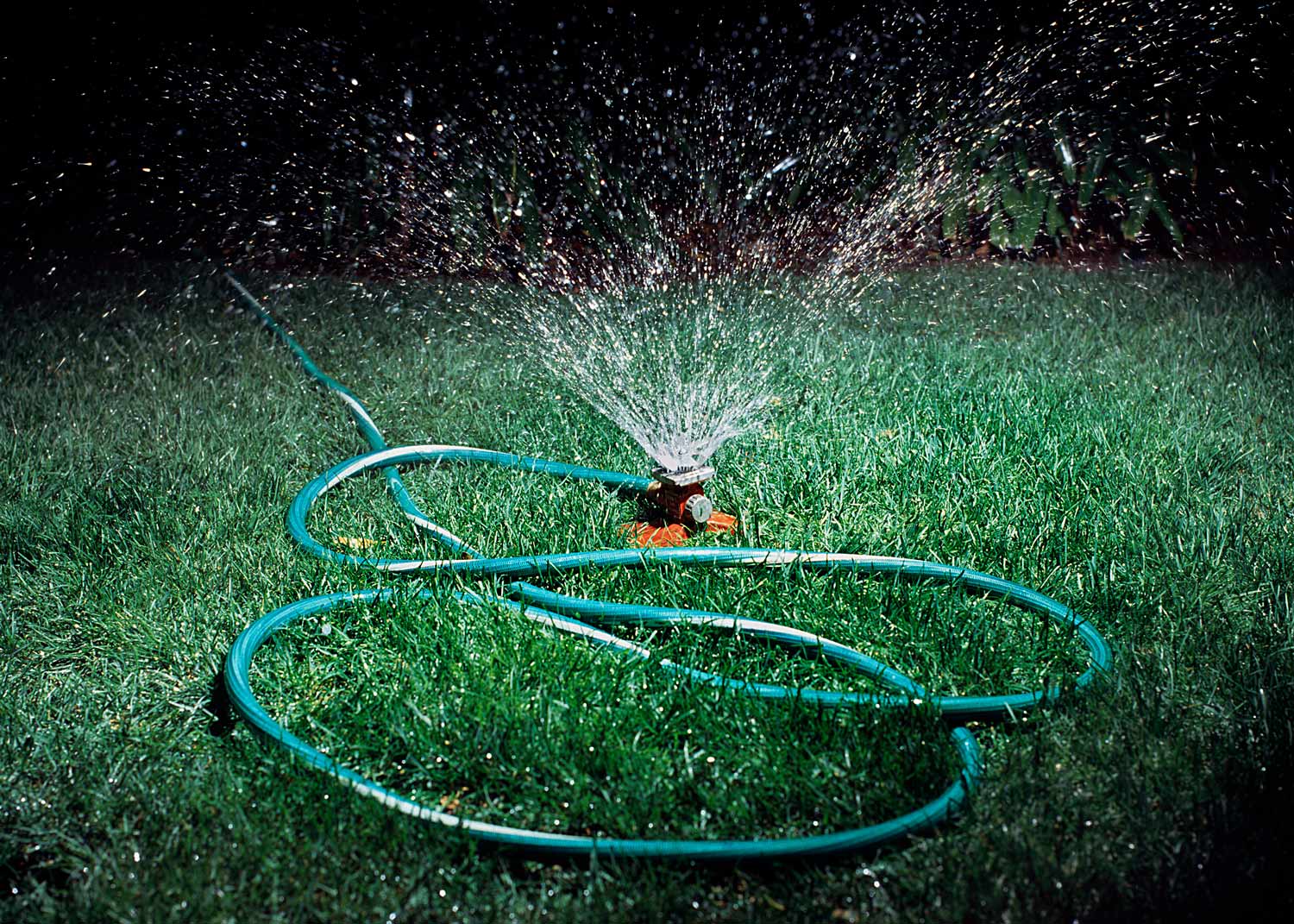 sprinkler watering lawn at night