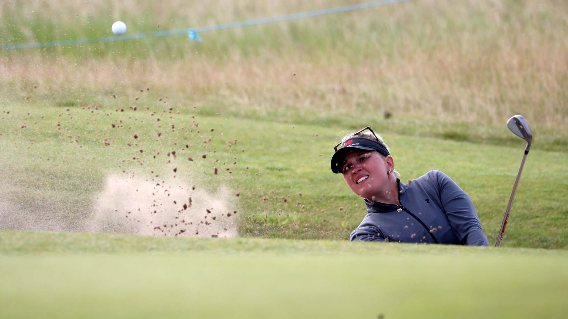 woman hits bunker shot