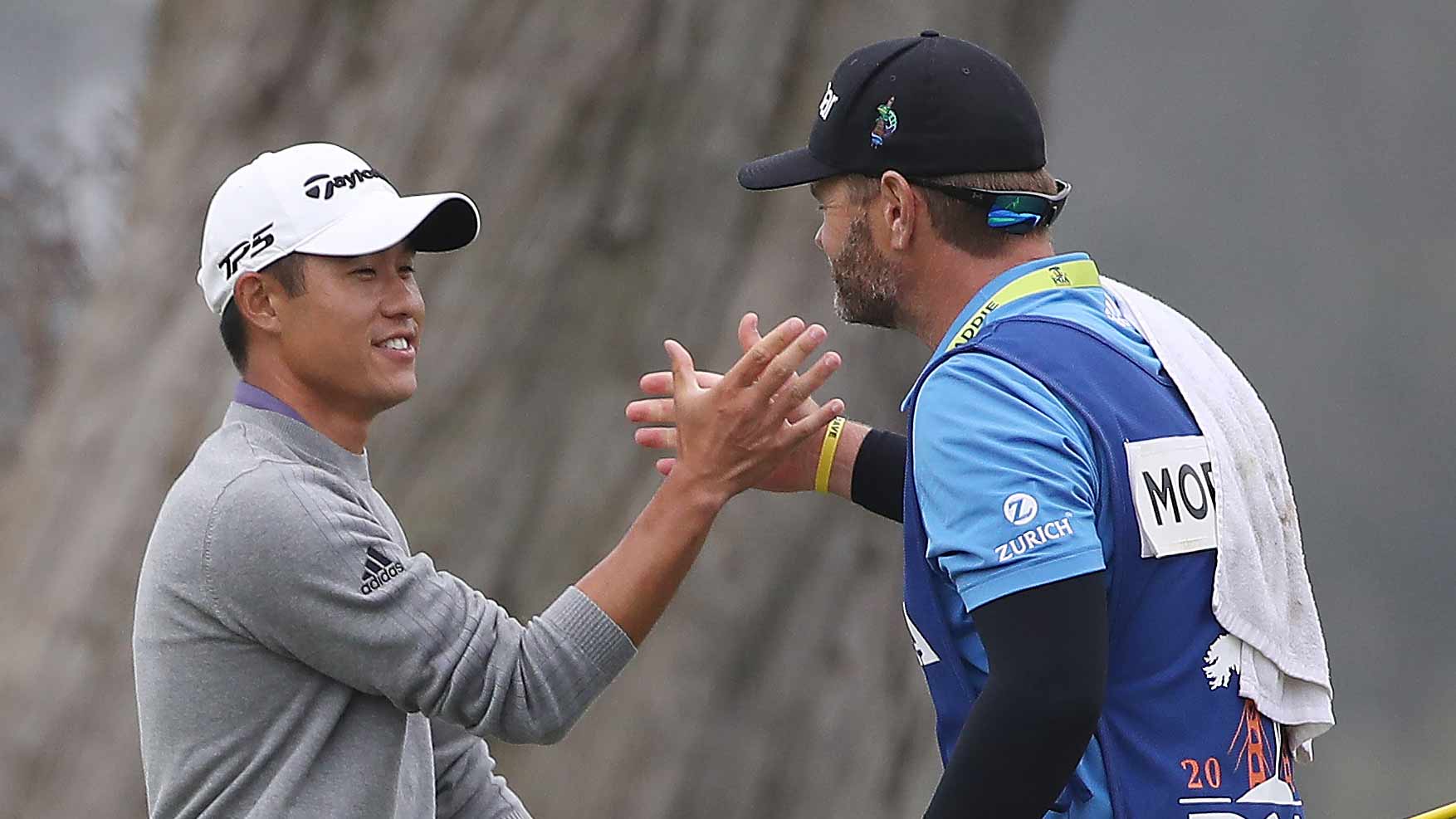 Collin Morikawa of the United States celebrates with caddie Jonathan Jakovac