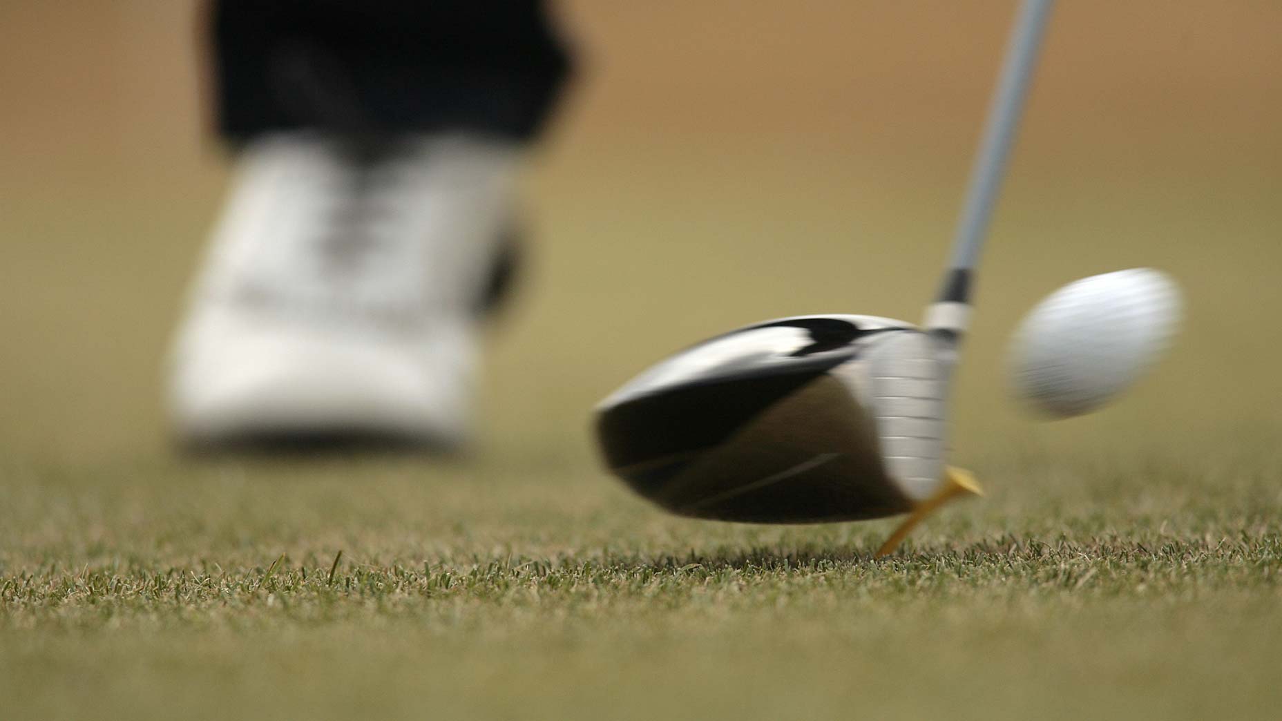 a golfer hits his driver off the tee