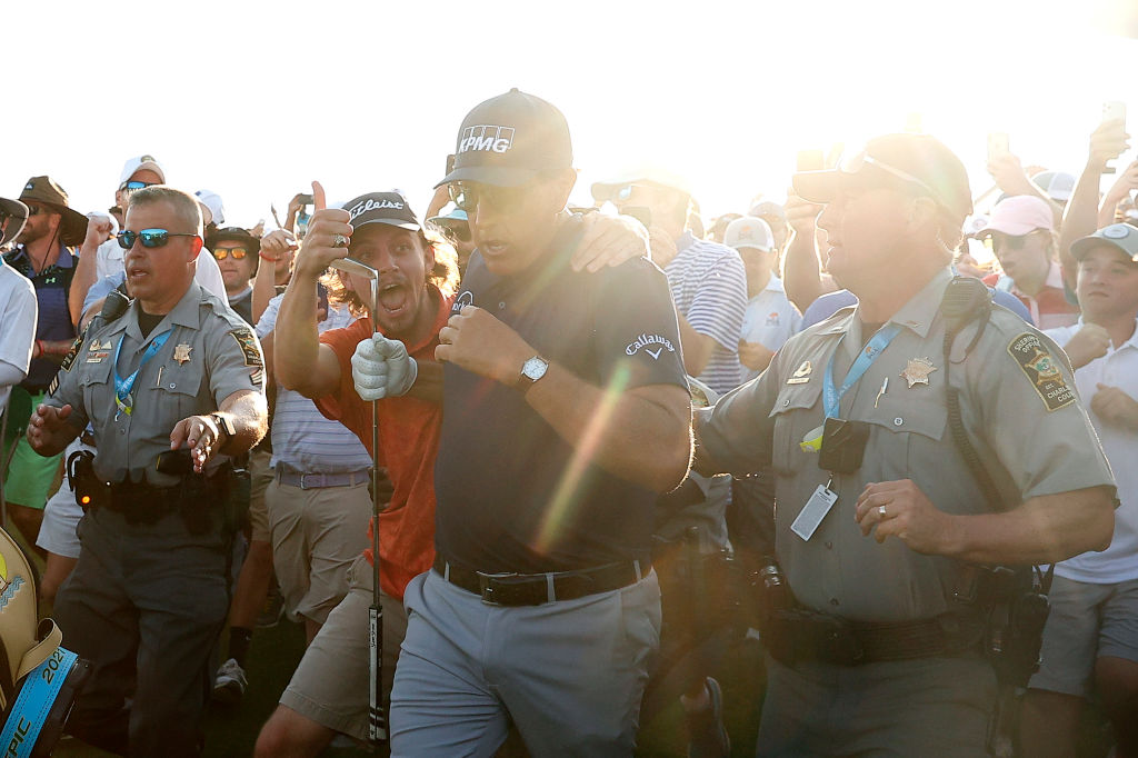 Phil Mickelson walks up the 18th fairway.