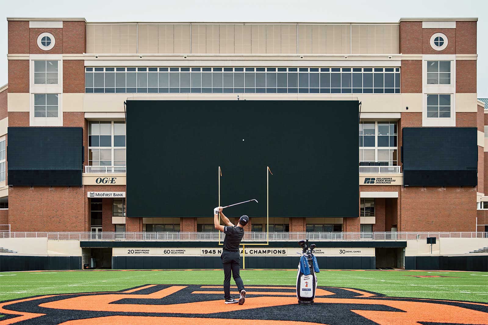 Viktor Hovland swings on the Oklahoma State football field.