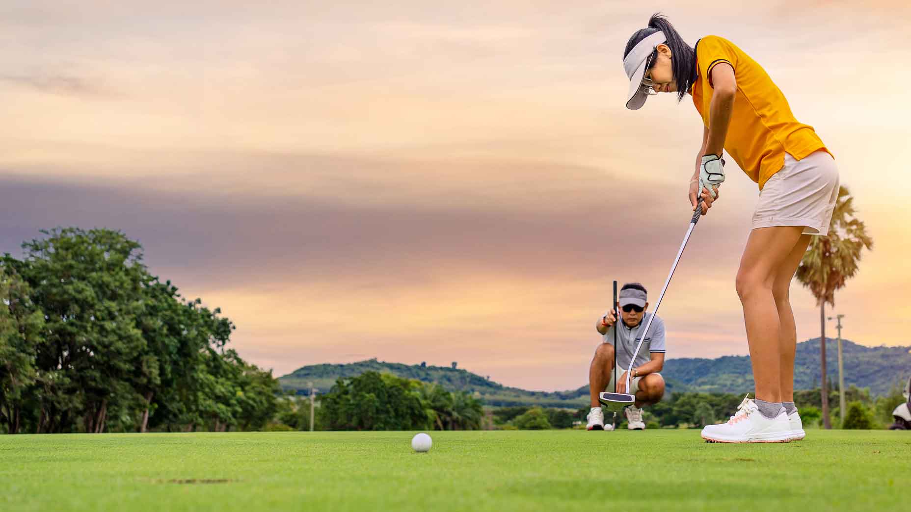 woman lines up a putt