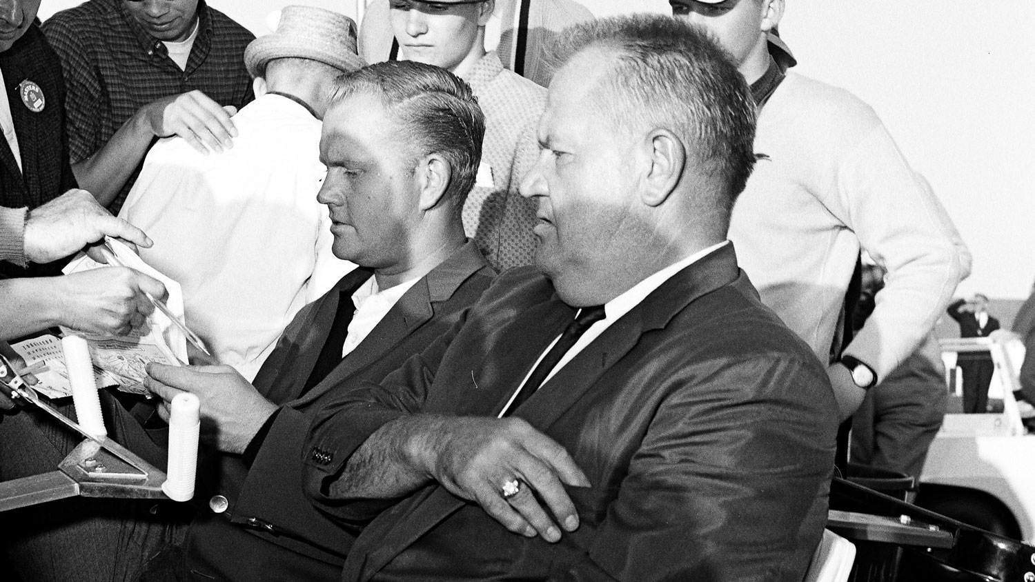 Masters Champion Jack Nicklaus signs autographs while seated next to his father, Charlie, during the 1963 Masters Tournament at Augusta National Golf Club 0n April 7th, 1963 in Augusta, Georgia.
