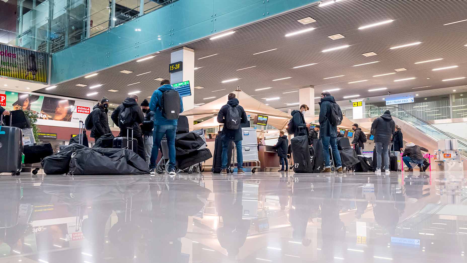 Travelers await for their bags at an airport.