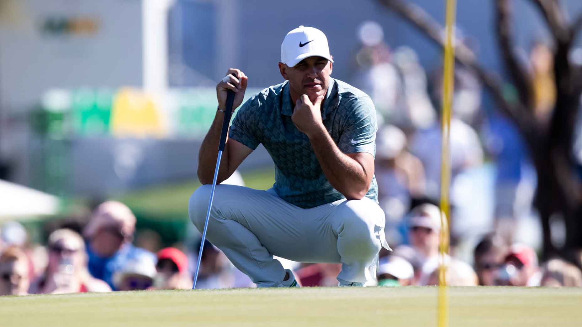 brooks koepka crouches over putt
