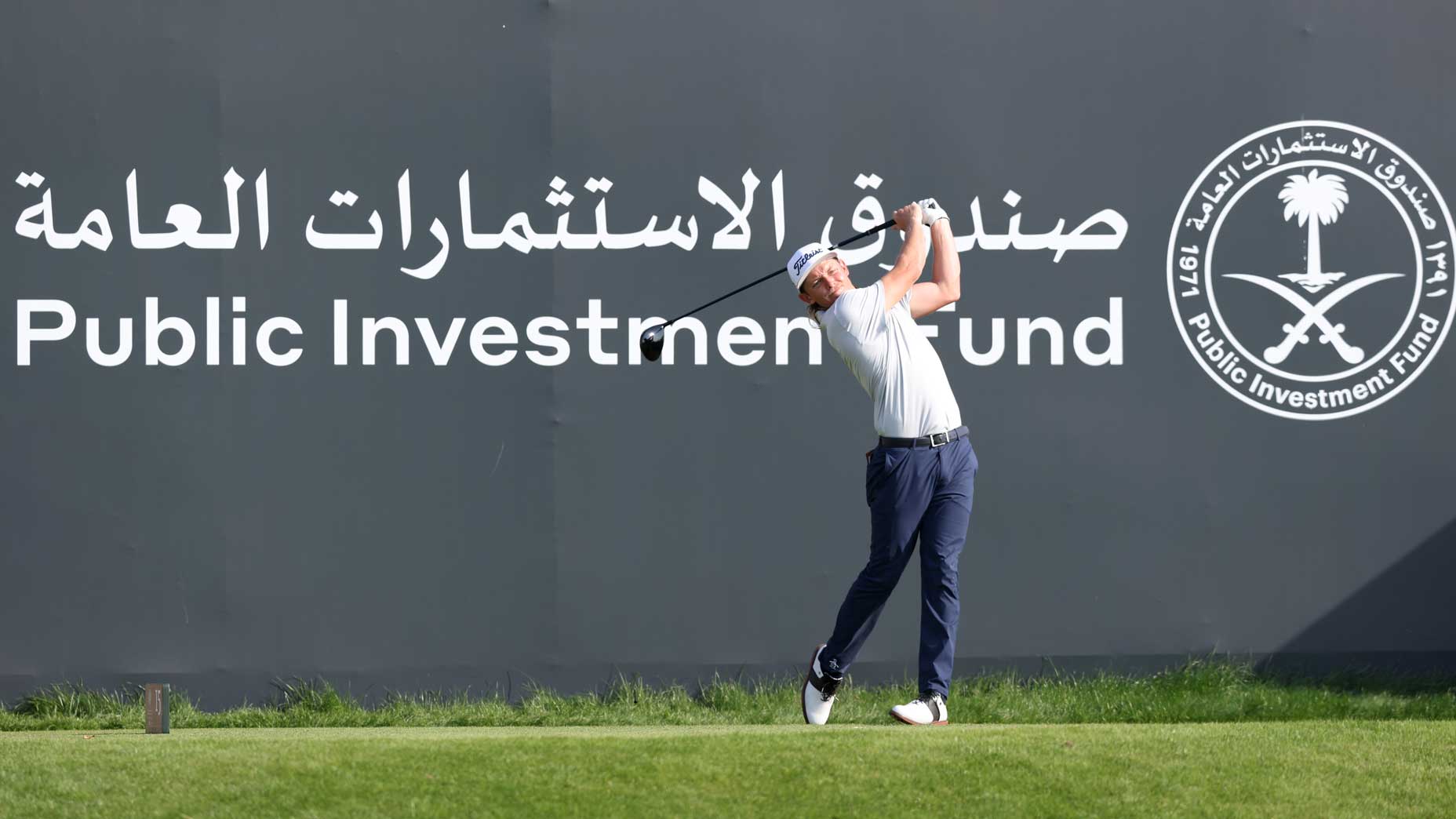 player hits in front of saudi investment fund sign