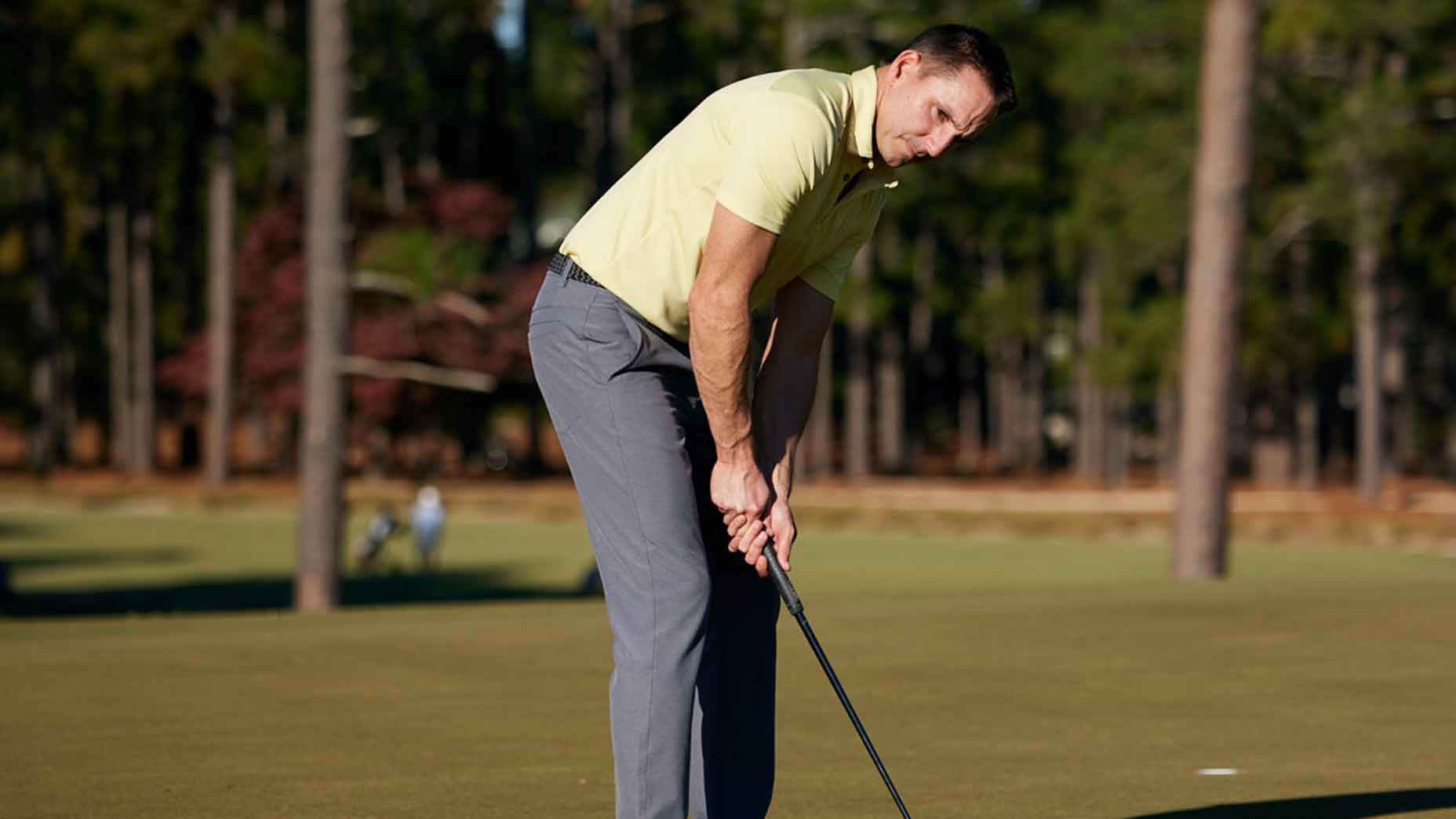 A man putts with his head up.