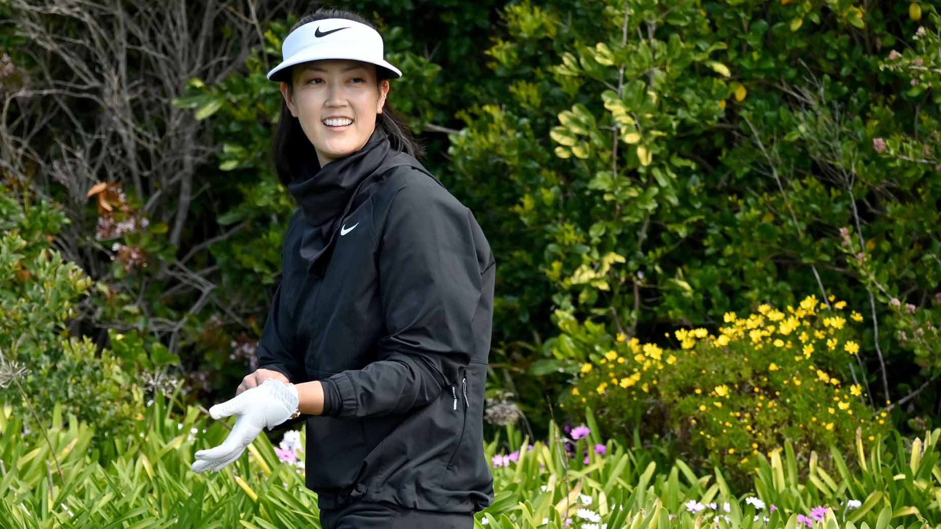 Michelle Wie West looks on.