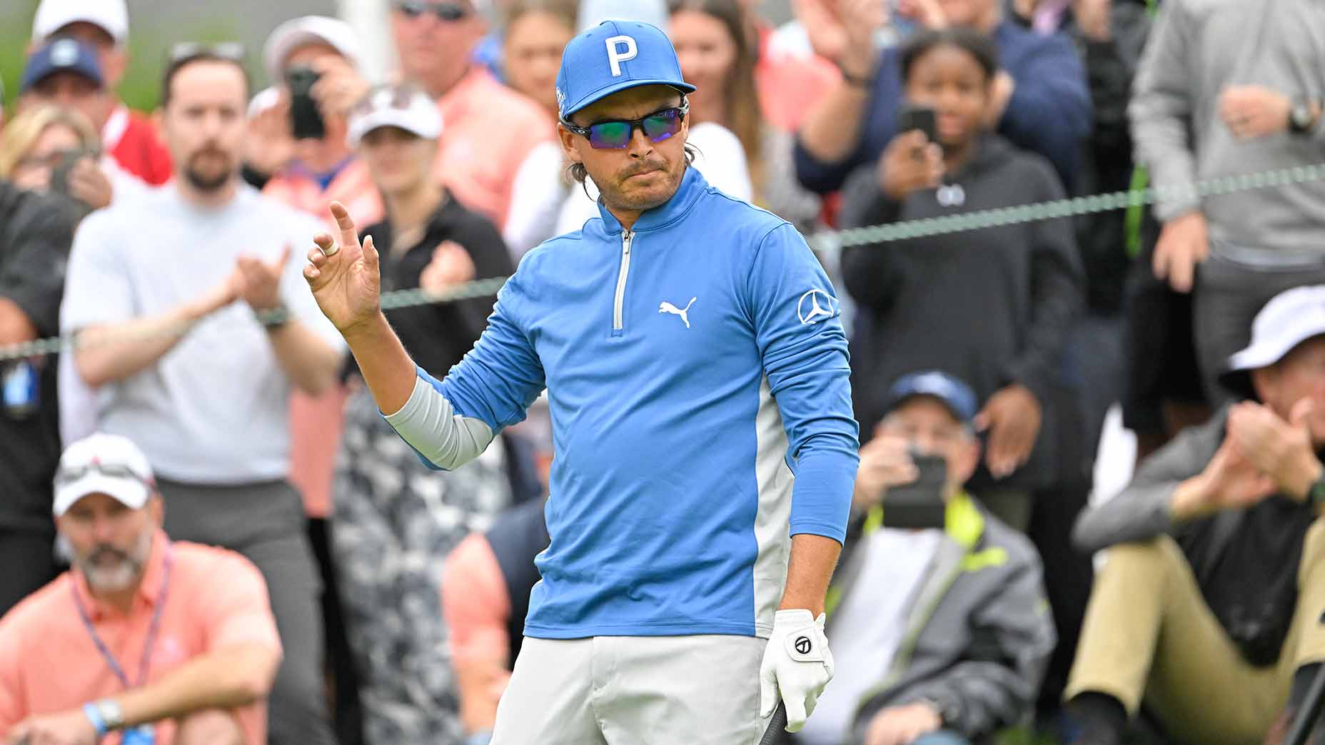 Rickie Fowler waves to the crowd on Thursday.