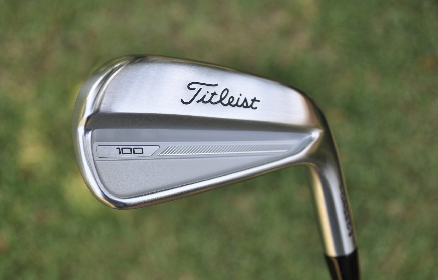 A Titleist T100 iron back bar pictured on a golf course