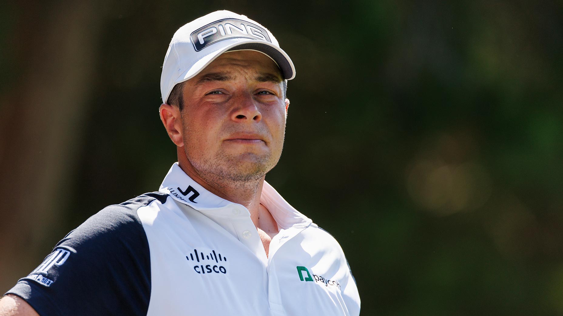 viktor hovland grimaces in a white shirt and hat at the FedEx St. Jude Invitational.