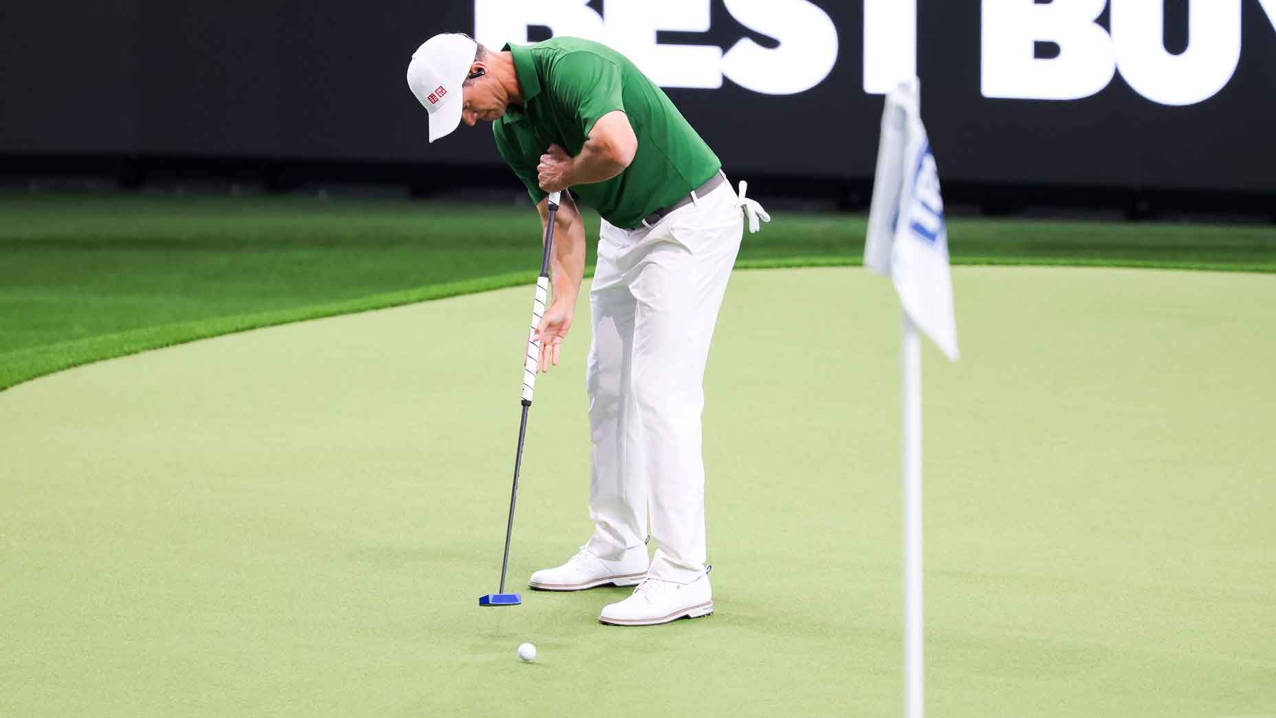 adam scott hits a putt during a tgl match