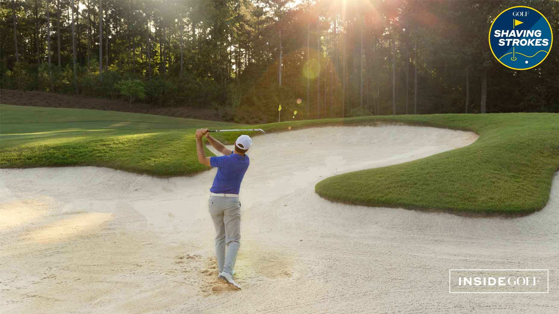 golfer hits shot from bunker with sun shining through the trees in background