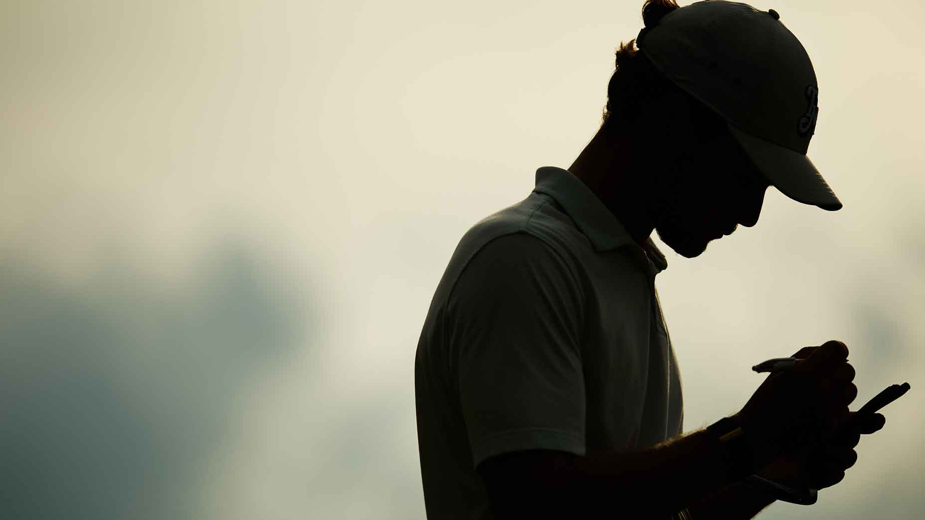 golfer uses pencil to write on scorecard