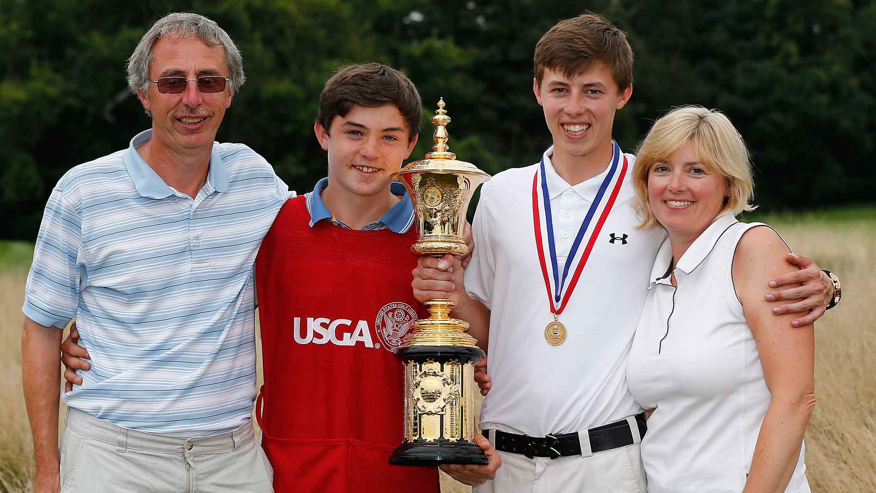 Matt Fitzpatrick of England holds the Havemeyer trophy with father Russell, his brother Alex Fitzpatrick, and his mother Sue after hewinning the 2013 U.S. Amateur Championship