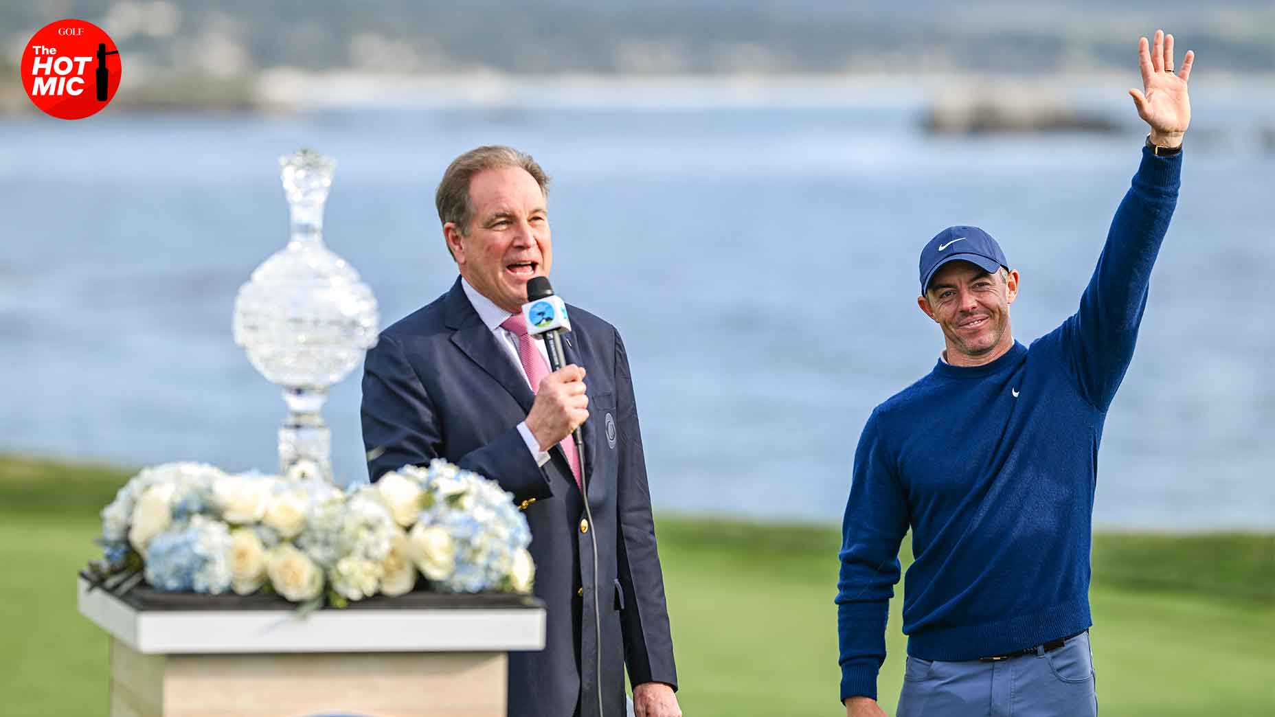 rory mcilroy and jim nantz pose next to AT&T Pebble Beach trophy.