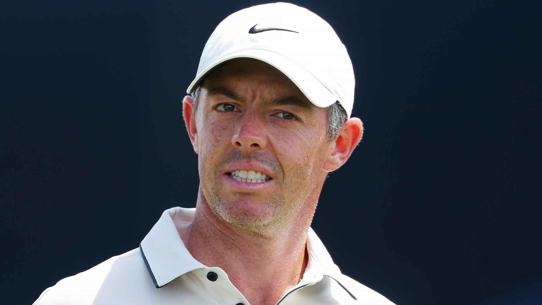 rory mcilroy looks pained at the pga championship in white hat and white shirt