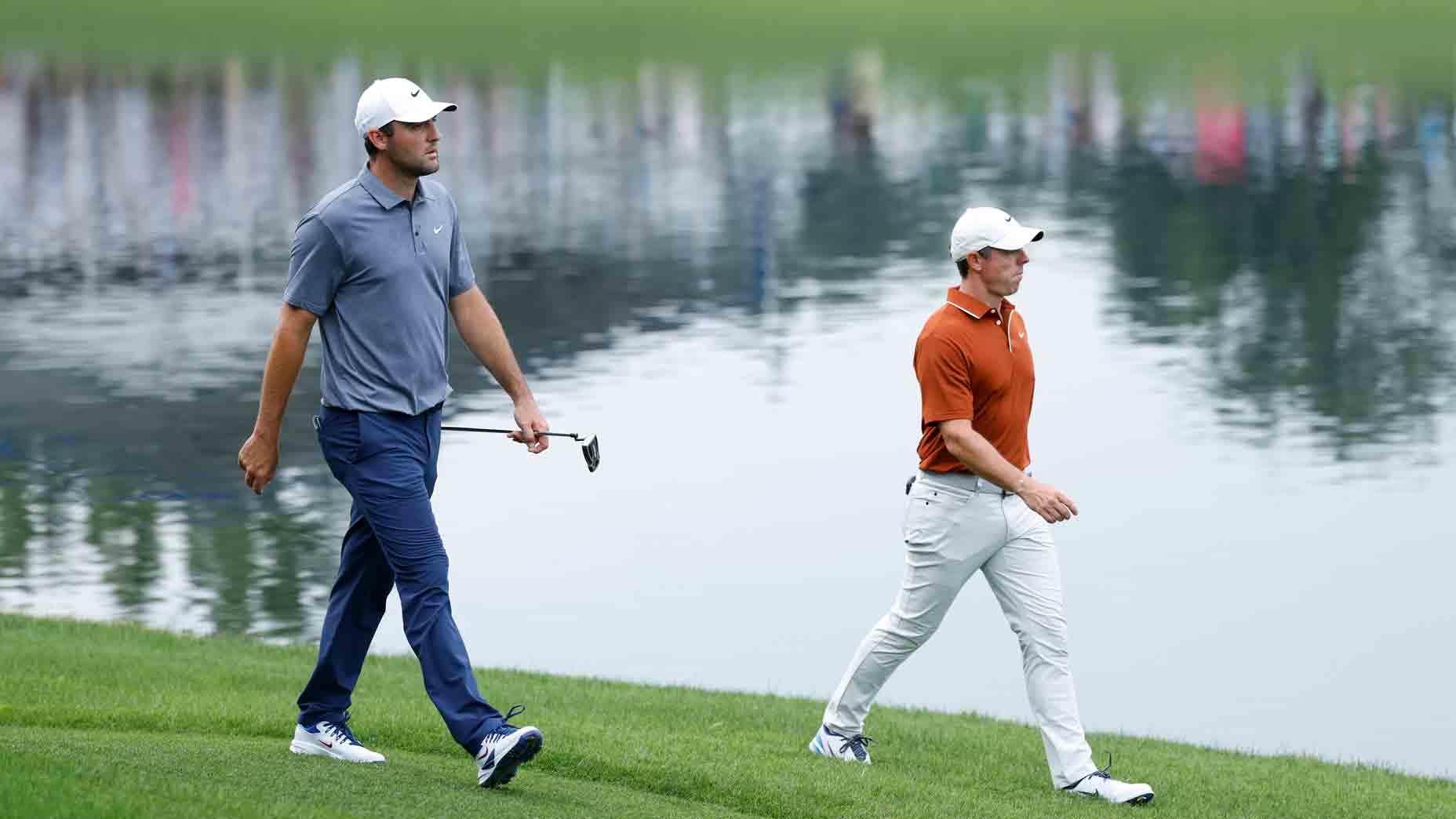 PGA Tour pros Scottie Scheffler, Rory McIlroy walk a golf course.
