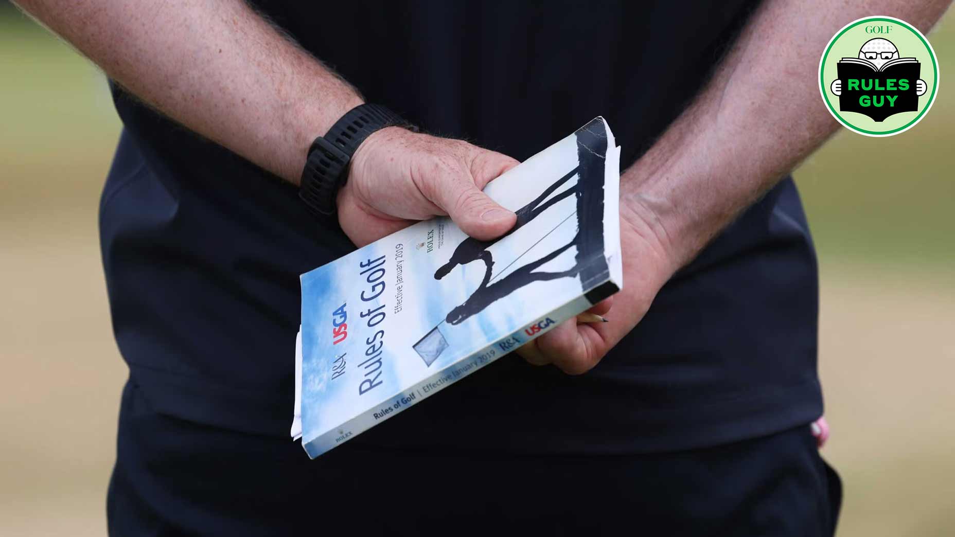 man holding the rules of golf