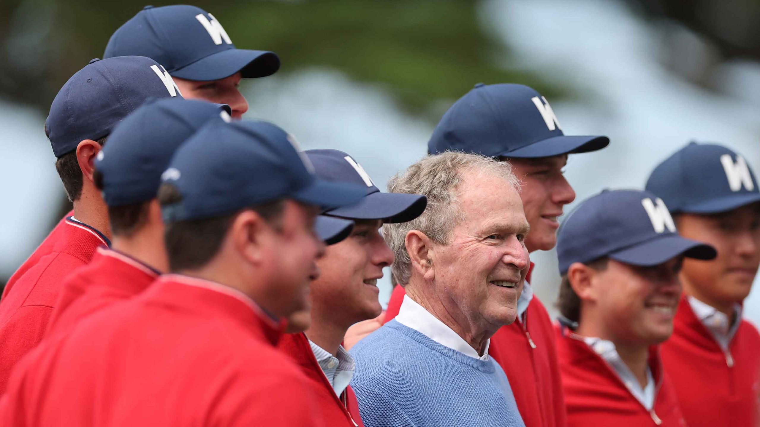 Former U.S. President George W. Bush poses with the Team United States after a practice round ahead of The 50th Walker Cup