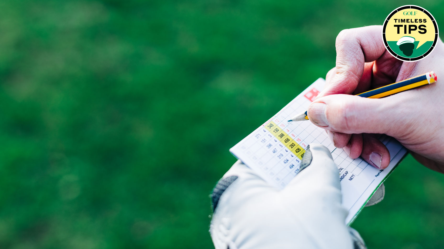 A male golfer writes his score - daytime view