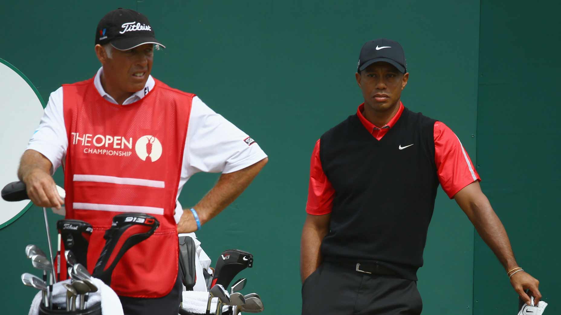 Caddie Steve Williams for Adam Scott (not seen) stands by Tiger Woods at the 2013 Open Championship.