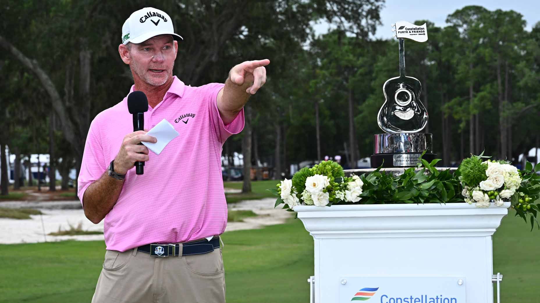 Tommy Gainey ppints with trophy after winning the 2025 Constellation FURYK & FRIENDS tournament.
